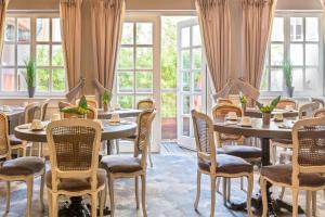 un restaurant avec des tables, des chaises et des fenêtres dans l'établissement Best Western Plus Hotel Villa D'est, à Strasbourg