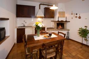 uma cozinha e sala de jantar com uma mesa e uma lareira em Brigolante Guest Apartments em Assis