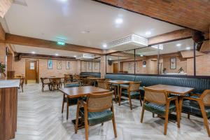 a dining room with wooden tables and chairs at Best Western Tbilisi City Center in Tbilisi City