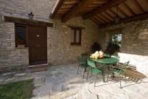 a green table and chairs on a patio at Brigolante Guest Apartments in Assisi