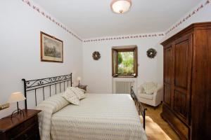 a bedroom with a bed and a dresser and a window at Brigolante Guest Apartments in Assisi