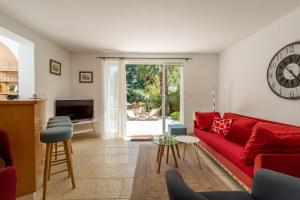 sala de estar con sofá rojo y mesa en Domaine du Peymian-La Bastide, en La Ciotat