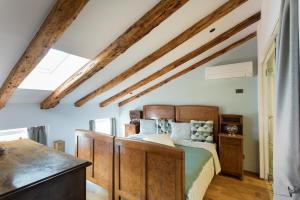 a bedroom with a bed and wooden beams at Špacapanova hiša in Komen