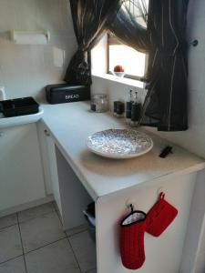 a small kitchen with a counter with a plate on it at Villa Monique Self Catering Apartment in Sedgefield