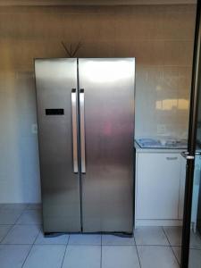 a stainless steel refrigerator in a kitchen at Villa Monique Self Catering Apartment in Sedgefield