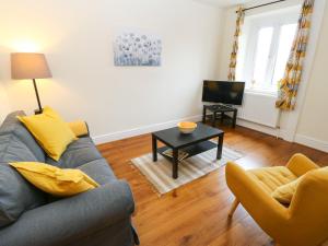 a living room with a couch and a table at Rock Cottage in Bakewell