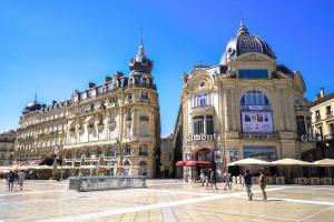 a large building with people walking in front of it at Hôtel Royal - Centre Comédie in Montpellier