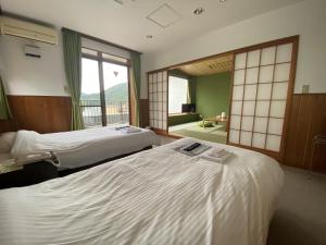 Łóżko lub łóżka w pokoju w obiekcie 伊豆三津浜国際旅館しおさい