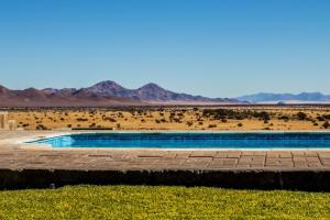 a swimming pool in the middle of the desert at At Kronenhof Lodge in Duwisib