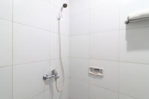 een douche met een douchekop in de badkamer bij AMS Hotel Koja in Jakarta