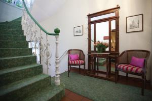 曼海姆的住宿－科法爾斯圖本酒店，楼梯,带两把椅子和一张桌子,还有镜子