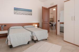 a hotel room with two beds and a desk at Residence Le Fontane in Villasimius