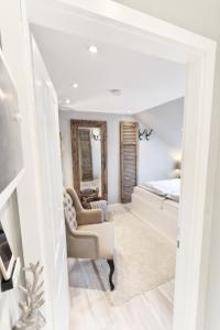 a bedroom with a bed and a couch and a chair at HOME Suites Maisonette mit Sauna in Braunlage +42 photos