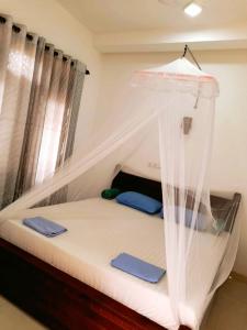 a bed with a canopy in a room at NEW SEA LION Guest House in Hikkaduwa