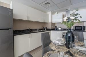 una cocina con una mesa con un jarrón de flores. en HiGuests - Luxury Apartment in the Iconic Park Towers, en Dubái