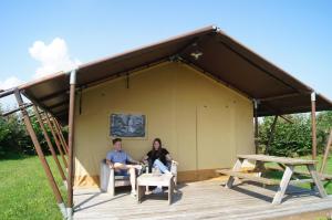 two people sitting inside of a tent at Hoeve Linnerveld XL in Sint Odiliënberg
