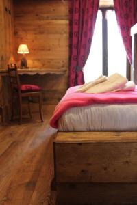 a bedroom with a bed and a chair and a table at FORESCH HUS CHAMBRES D'HOTES in Gressoney-Saint-Jean