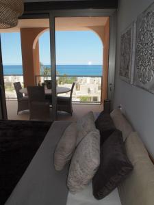 ビリャホヨサにあるVila Paradis 1-3 Fのソファ付きのベッドルーム1室、海の景色を望むベッドルーム1室