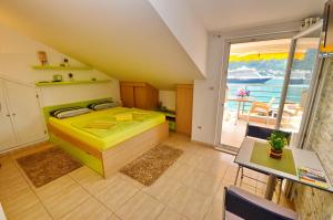 a bedroom with a yellow bed and a balcony at Palma Apartments in Kotor
