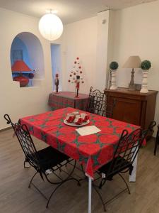 a dining room table with a red table cloth at SUPERBE TRIPLEX MEUBLÉ TOUT CONFORT HYPER CENTRE ST CÉRÉ 3 CHAMBRES WIFI 120 M2 8 pers max in Saint-Céré