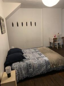 ein Schlafzimmer mit einem Bett, einem Tisch und einem sidx sidx sidx in der Unterkunft SUPERBE TRIPLEX MEUBLÉ TOUT CONFORT HYPER CENTRE ST CÉRÉ 3 CHAMBRES WIFI 120 M2 8 pers max in Saint-Céré