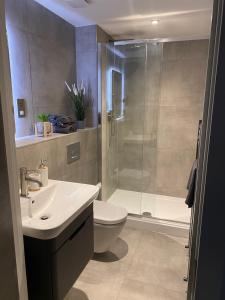 a bathroom with a shower and a toilet and a sink at Icona - Stylish apartment in brand new development! in York