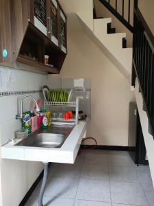 a kitchen with a sink and a staircase at Villa Amadeo in Batu