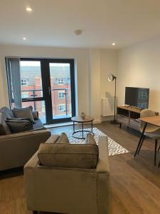 a living room with two couches and a television at Icona - Stylish apartment in brand new development! in York