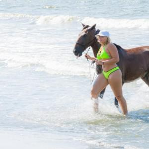 a woman in a bikini riding a horse on the beach at Ecohotel Kocoluu in San Bernardo del Viento