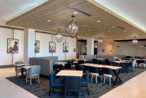 a dining room with tables and chairs and lights at La Quinta Inn & Suites by Wyndham Maricopa Copper Sky in Maricopa