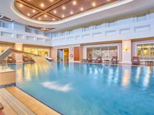a large swimming pool in a hotel with a large swimming pool at Rixos President Hotel Astana in Astana
