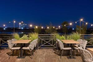 a patio with two tables and chairs at night at Radisson Hotel Tamboho Waterfront Antananarivo in Antananarivo