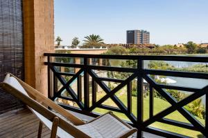 a balcony with a chair and a view of a city at Radisson Hotel Tamboho Waterfront Antananarivo in Antananarivo +119 photos