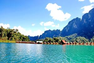a large body of water with mountains in the background at Khao Sok River Lodge Hotel in Khao Sok