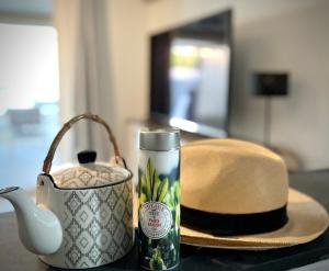 uma mesa com um chapéu, um bule de chá e uma garrafa em L'ALPILLE - Maison de vacances située à 10 mn à pied du centre ville de St Rémy avec place de parking privative em Saint-Rémy-de-Provence