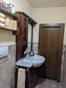 Łazienka z umywalką i drewnianymi drzwiami w obiekcie Casa Baldecchi - Pistoia Centro Storico w mieście Pistoia