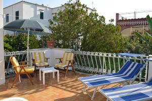 a patio with chairs and a table and an umbrella at IL Kent in Ischia