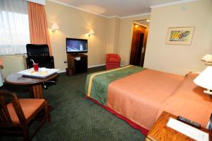 a hotel room with a bed and a table and a television at Hotel Diego De Almagro Calama in Calama
