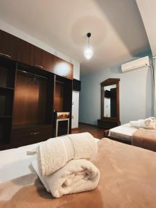 una habitación de hotel con 2 camas y una toalla en la cama en ODA Guest House en Korçë