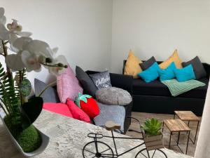 uma sala de estar com um sofá preto com almofadas coloridas em Gästewohnung Mönchengladbach Rheindahlen em Mönchengladbach