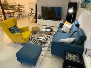 a living room with a blue couch and two yellow chairs at Hwadam Inn in Gunsan