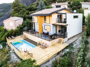 a house with a large deck and a swimming pool at Halte Air et Go in Marcoux