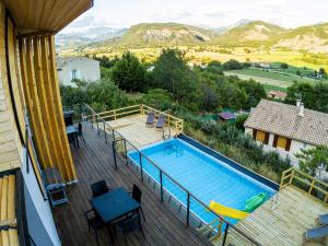 a swimming pool on a deck with a view of mountains at Halte Air et Go in Marcoux