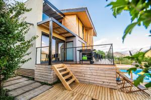 a house with a deck with a swing at Halte Air et Go in Marcoux