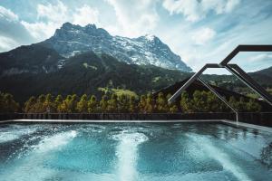 a swimming pool with a mountain in the background at Boutique Hotel Glacier in Grindelwald