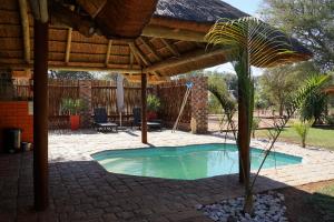 a small swimming pool under a wooden roof at Kwele Game Lodge in Beauty
