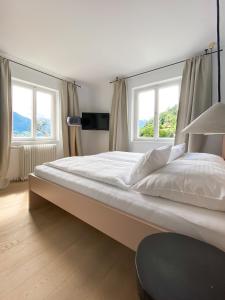 sypialnia z dużym łóżkiem i 2 oknami w obiekcie Appartements Steiner - SKI IN - SKI OUT w mieście Zell am See