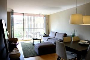 een woonkamer met een bank en een tafel bij Passeig de gracia sun apartament balcony 2 bedrooms in Barcelona