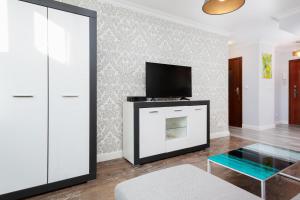華沙的住宿－Warsaw Apartament Rondo ONZ，客厅配有电视、沙发和桌子