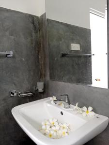 La salle de bains est pourvue d'un lavabo et de fleurs. dans l'établissement Talalla Leisure, à Talalla South